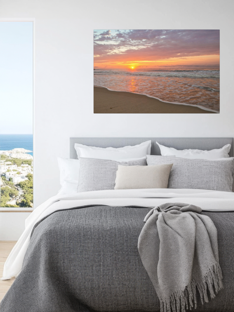 Bedroom with a canvas print of a vibrant sunrise over the Atlantic Ocean.