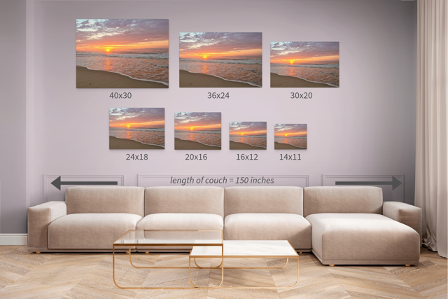 Canvas prints of a vibrant sunrise over the Atlantic Ocean displayed above a sofa with measurements indicated.