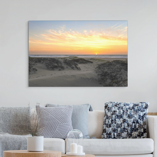 Canvas print of a beach scene with a sunset over sand dunes in a living room.