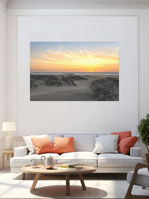 Living room with a large framed picture of a beach sunset above a white sofa with colorful cushions.