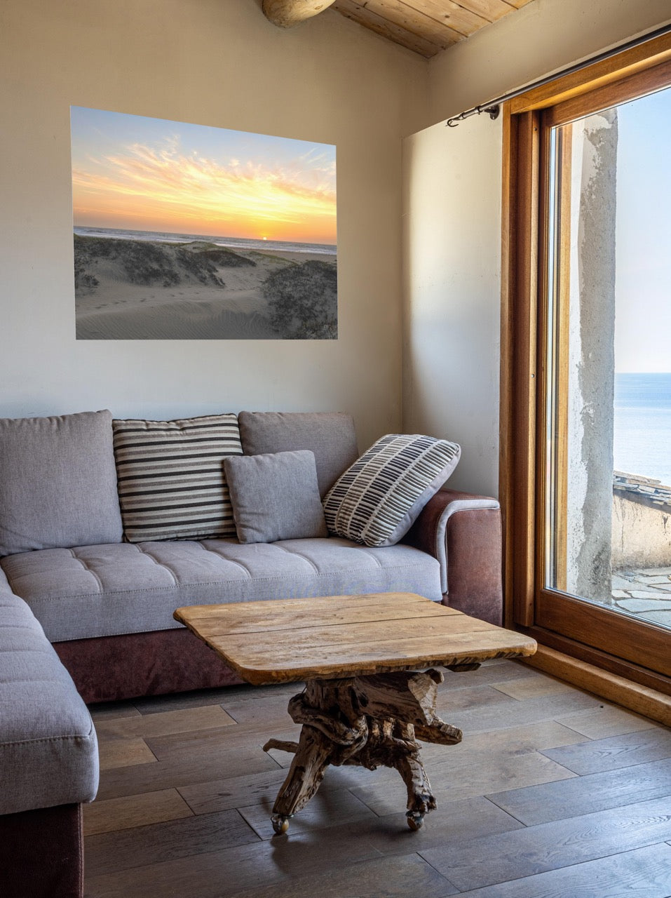 Living room with a gray sofa, wooden coffee table, and a canvas print of a beach dunes sunset.