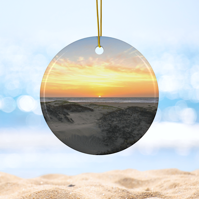 Ceramic Christmas ornament featuring an original photograph of a sunset over coastal sand dunes.