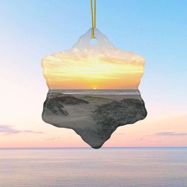 Ceramic Christmas ornament featuring an original photograph of a sunset over coastal sand dunes