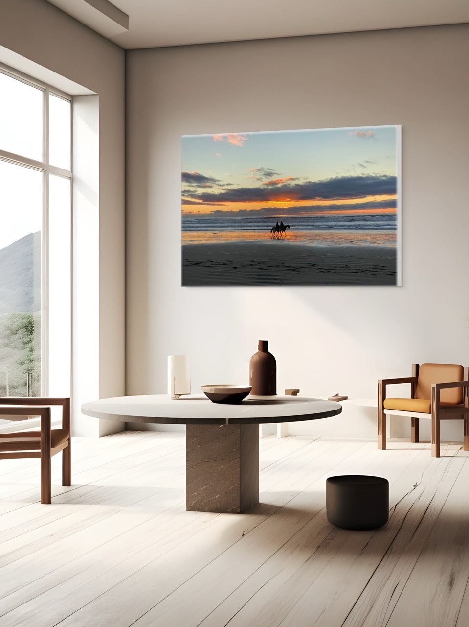 Modern living room with a canvas print of two horseback riders on the beach at sunset on the wall.