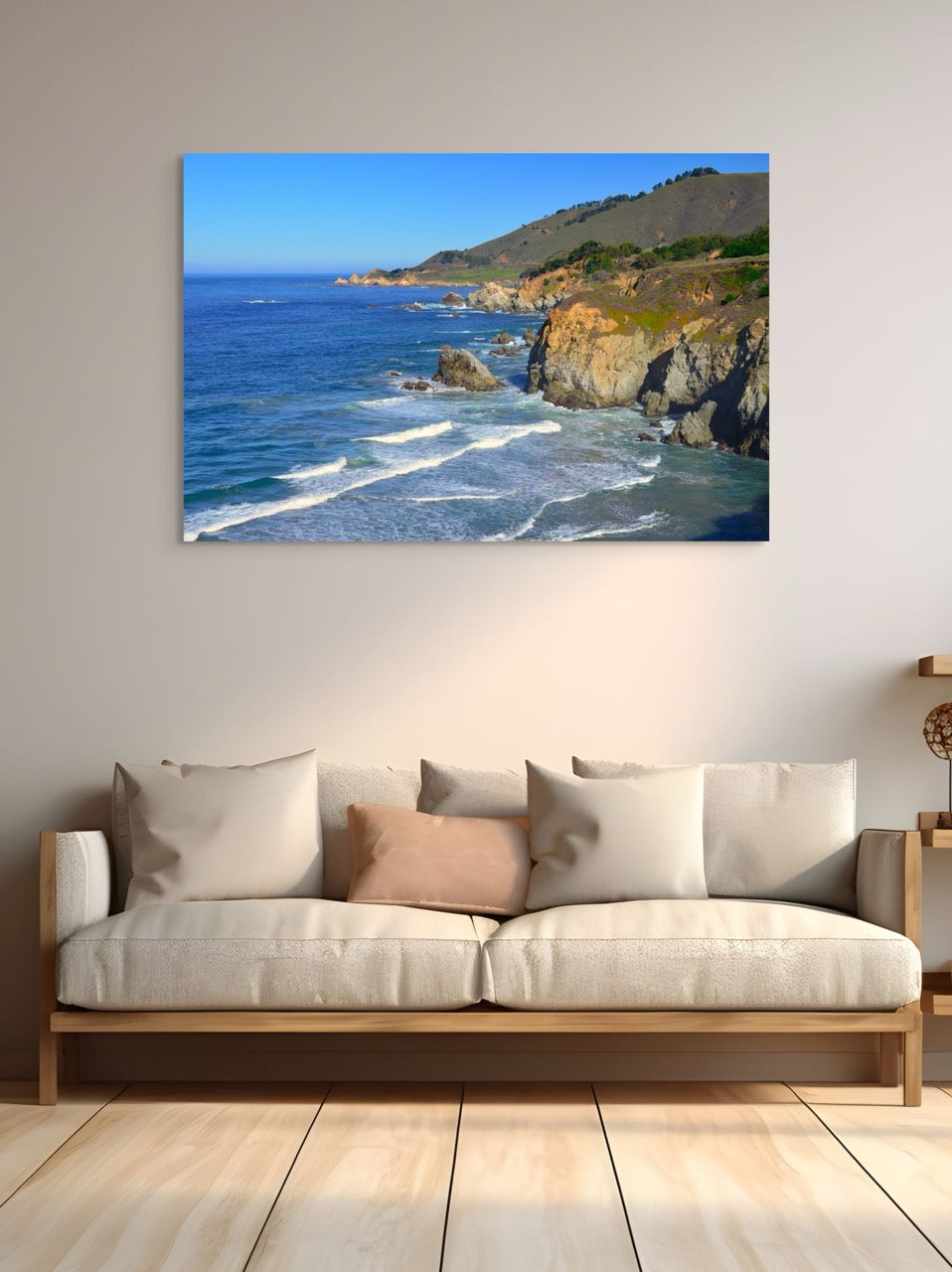 A canvas print of the rugged coastline in Big Sur, California above a sofa in a living room