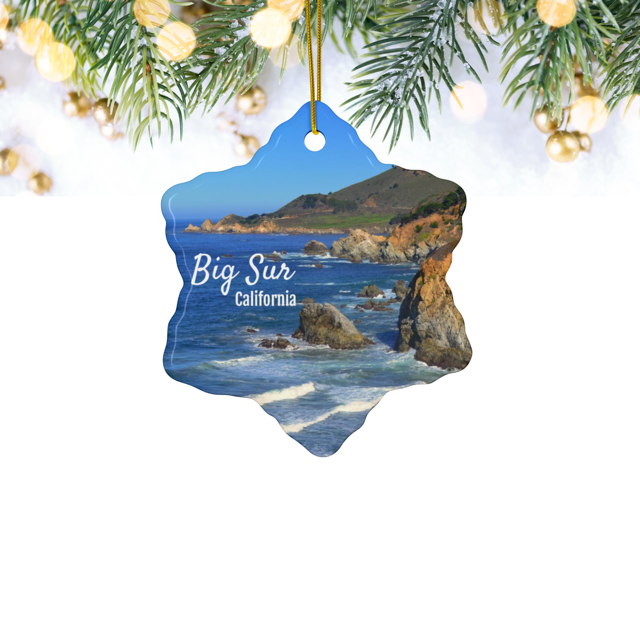 Ceramic Christmas ornament featuring a photograph of the rugged cliffs and deep blue Pacific Ocean along the Big Sur coastline in California, hanging against a white background.