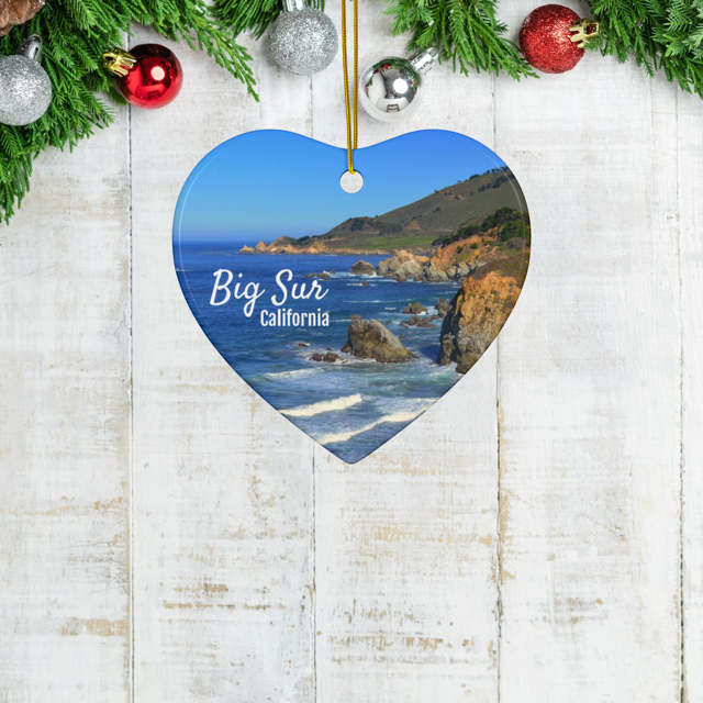 Heart-shaped ceramic Christmas ornament featuring a photograph of the rugged cliffs and deep blue Pacific Ocean along the Big Sur coastline in California 