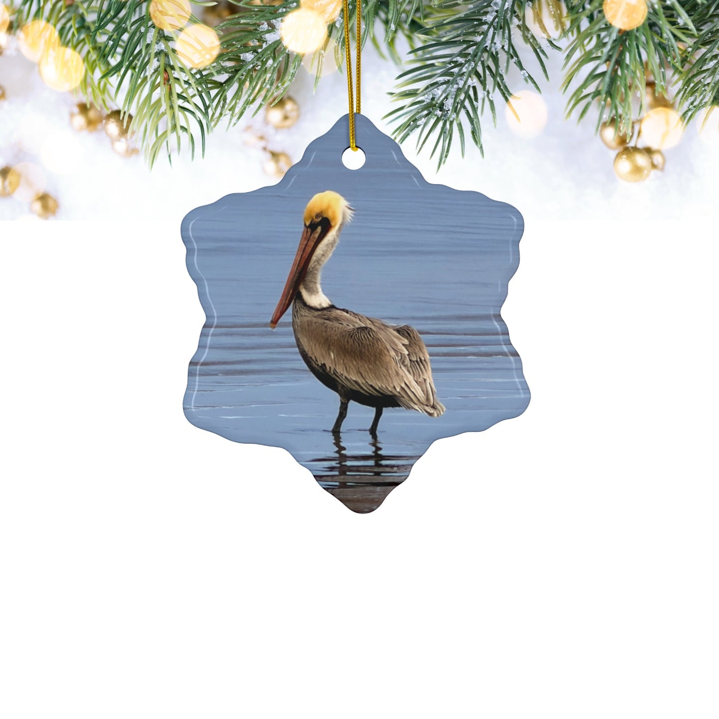 Ceramic holiday ornament featuring a professional photograph of a Brown Pelican standing on the shoreline.