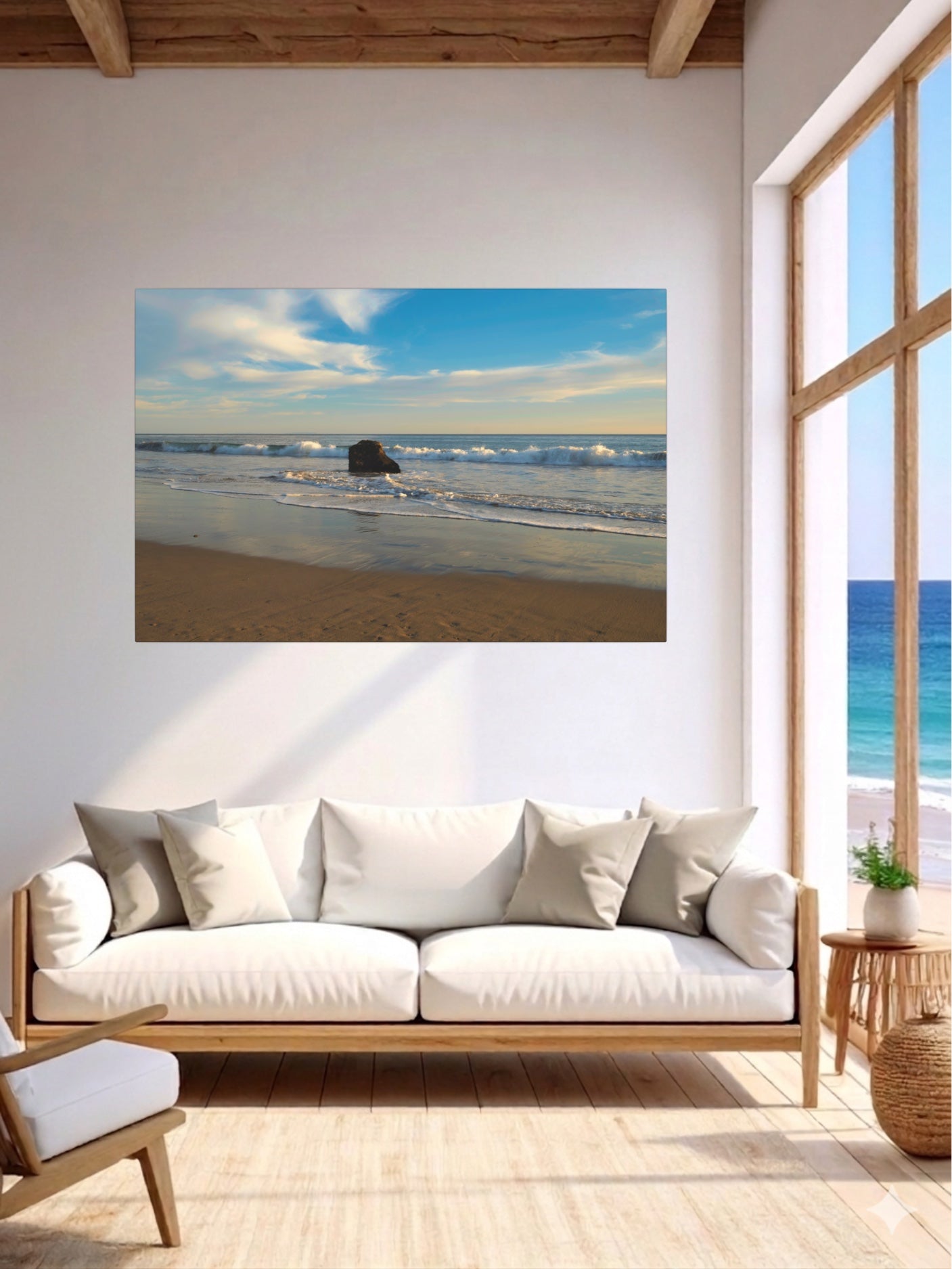 Living room with a solitary rock on a California beach with ocean wave foam and sky reflection canvas print on the wall above a sofa.
