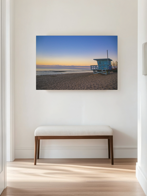 Canvas print of a California lifeguard tower at sunrise on a wall above a bench in a room