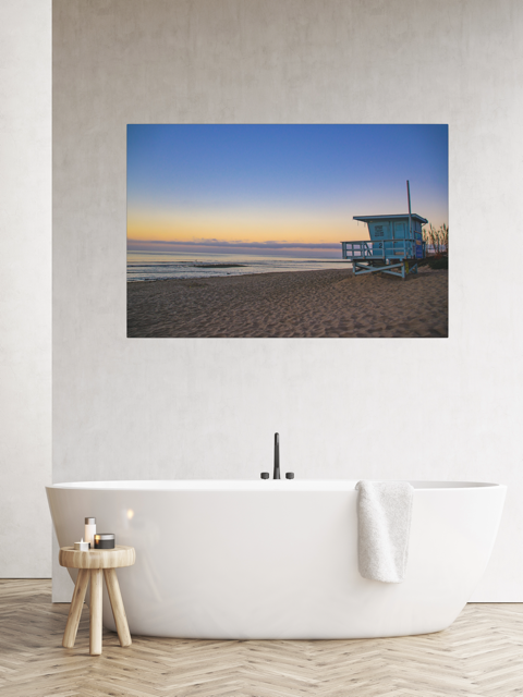 Canvas print of a California lifeguard tower at sunrise on a wall above a bathtub.