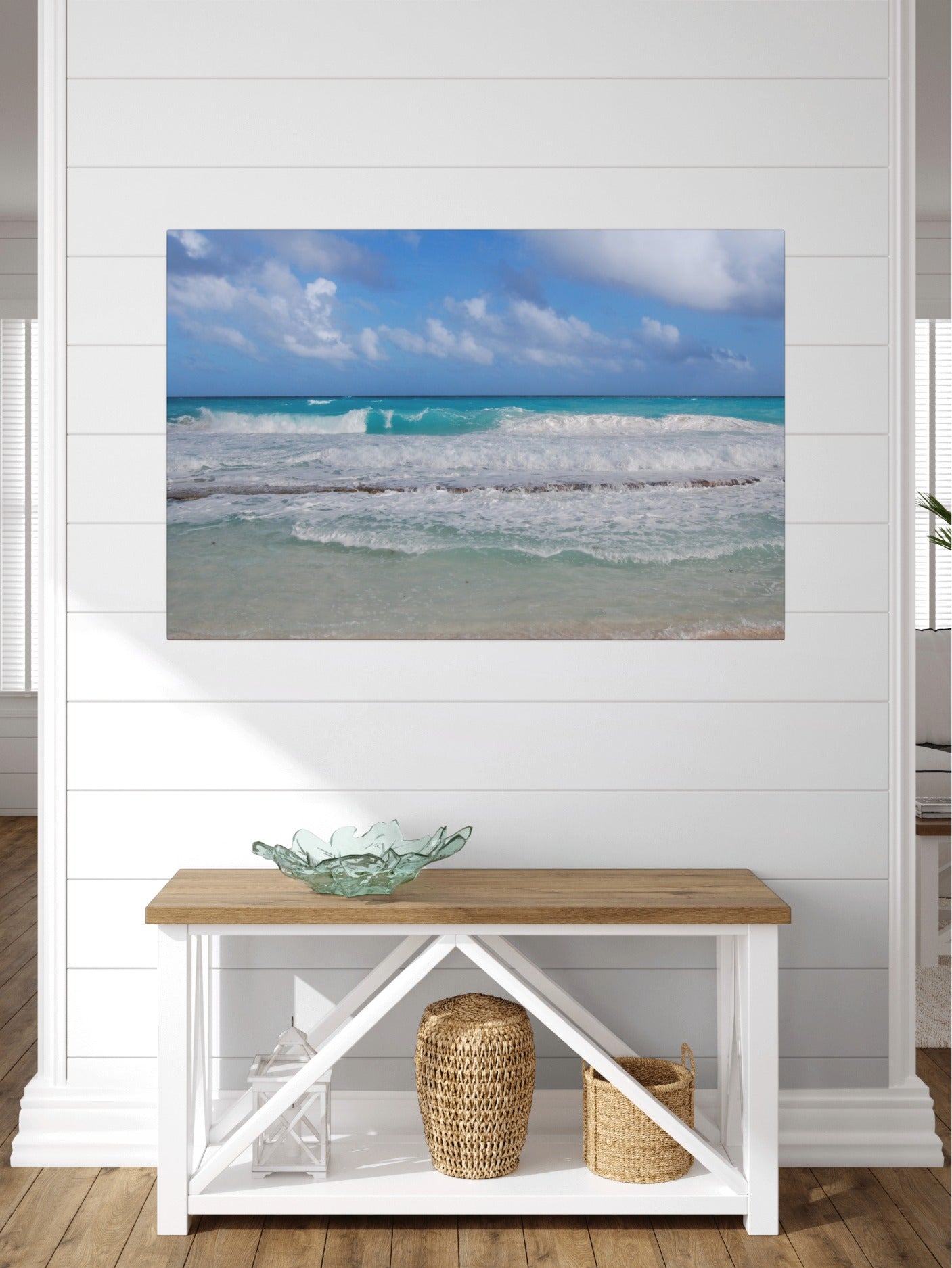 Cancun Caribbean turquoise waves breaking on sand canvas print on a wall above a wooden bench with decorative items.