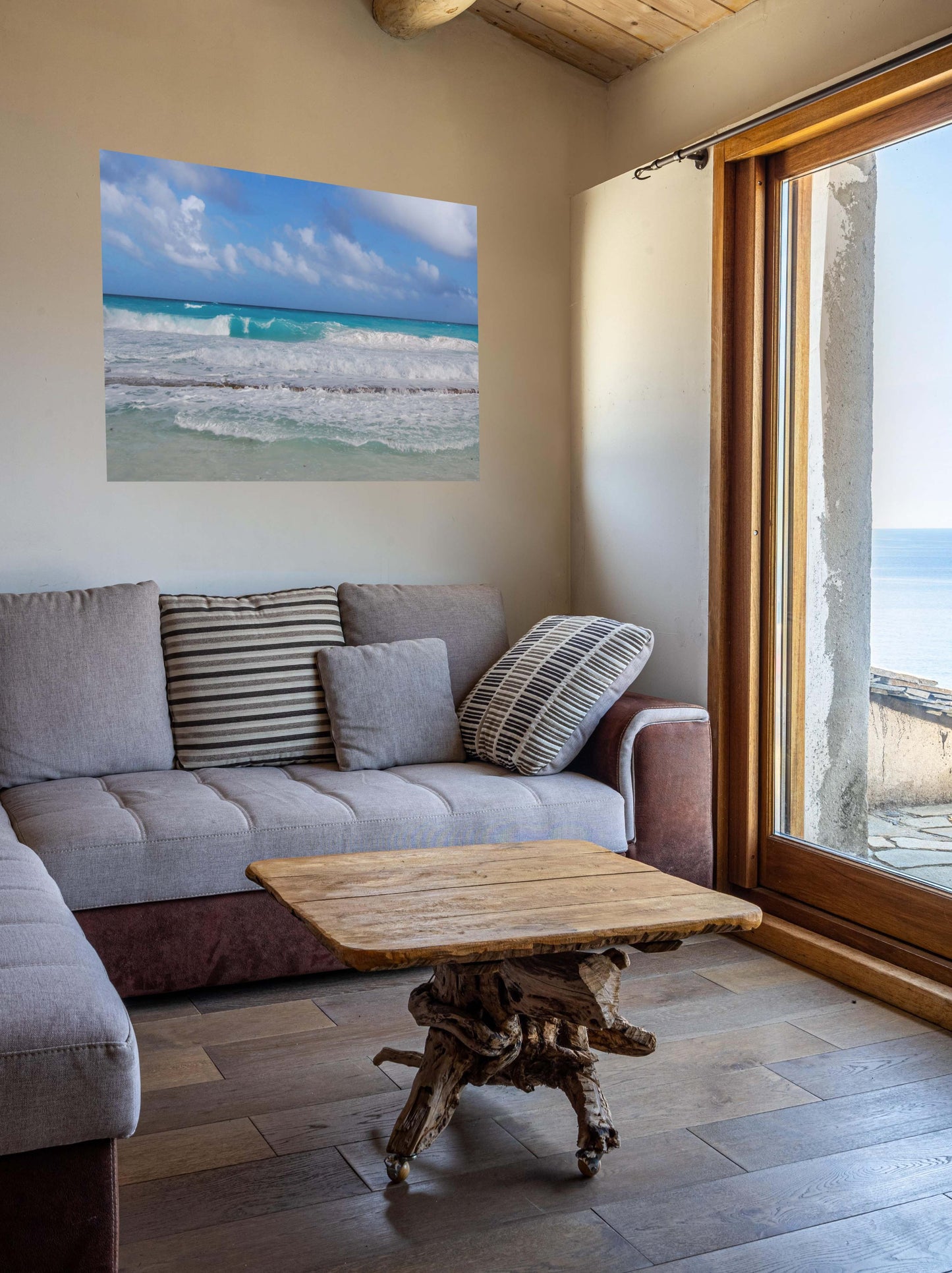 Living room with a gray sofa, wooden coffee table, and a Cancun Caribbean turquoise waves breaking on sand canvas print on the wall.