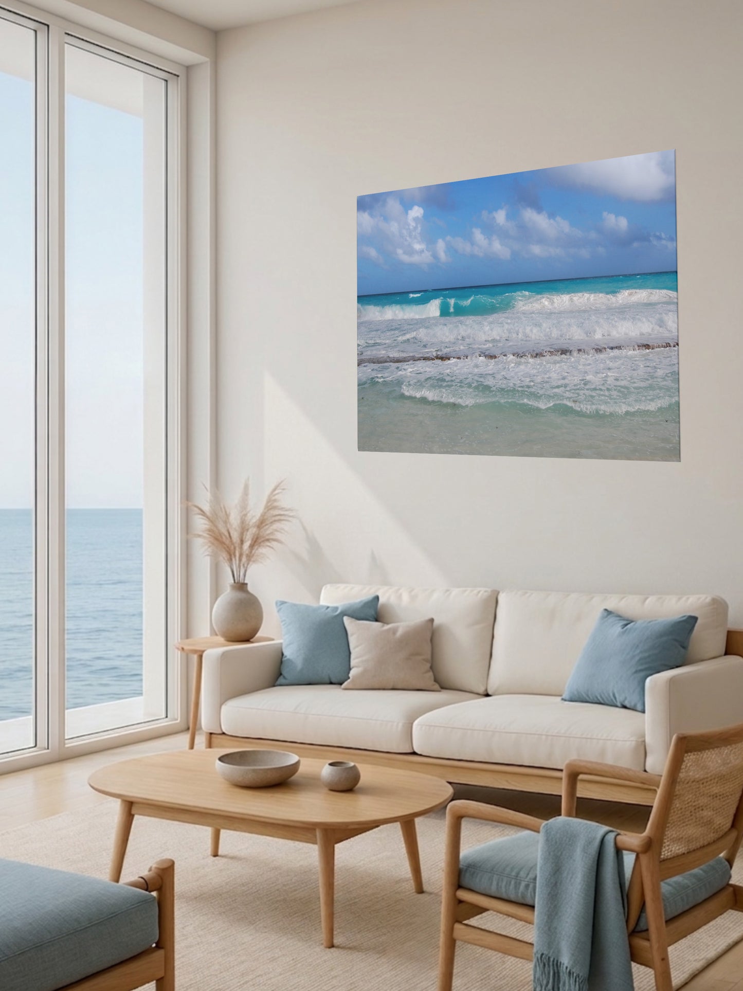 Living room with a large window view of the ocean, a beige sofa with blue cushions, and a Cancun Caribbean turquoise waves breaking on sand canvas print