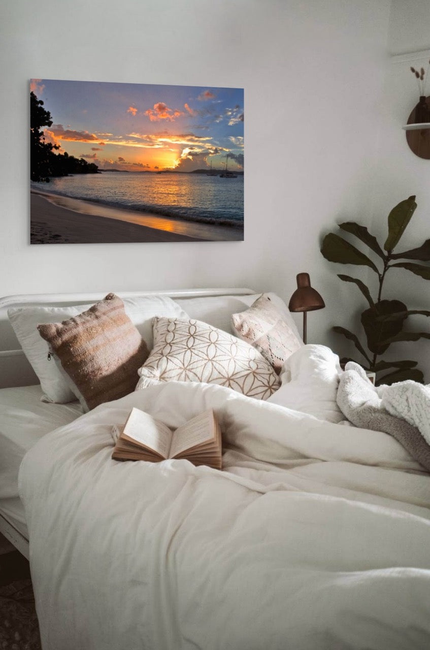 Bedroom with a tropical sunset canvas print on the wall above a bed.