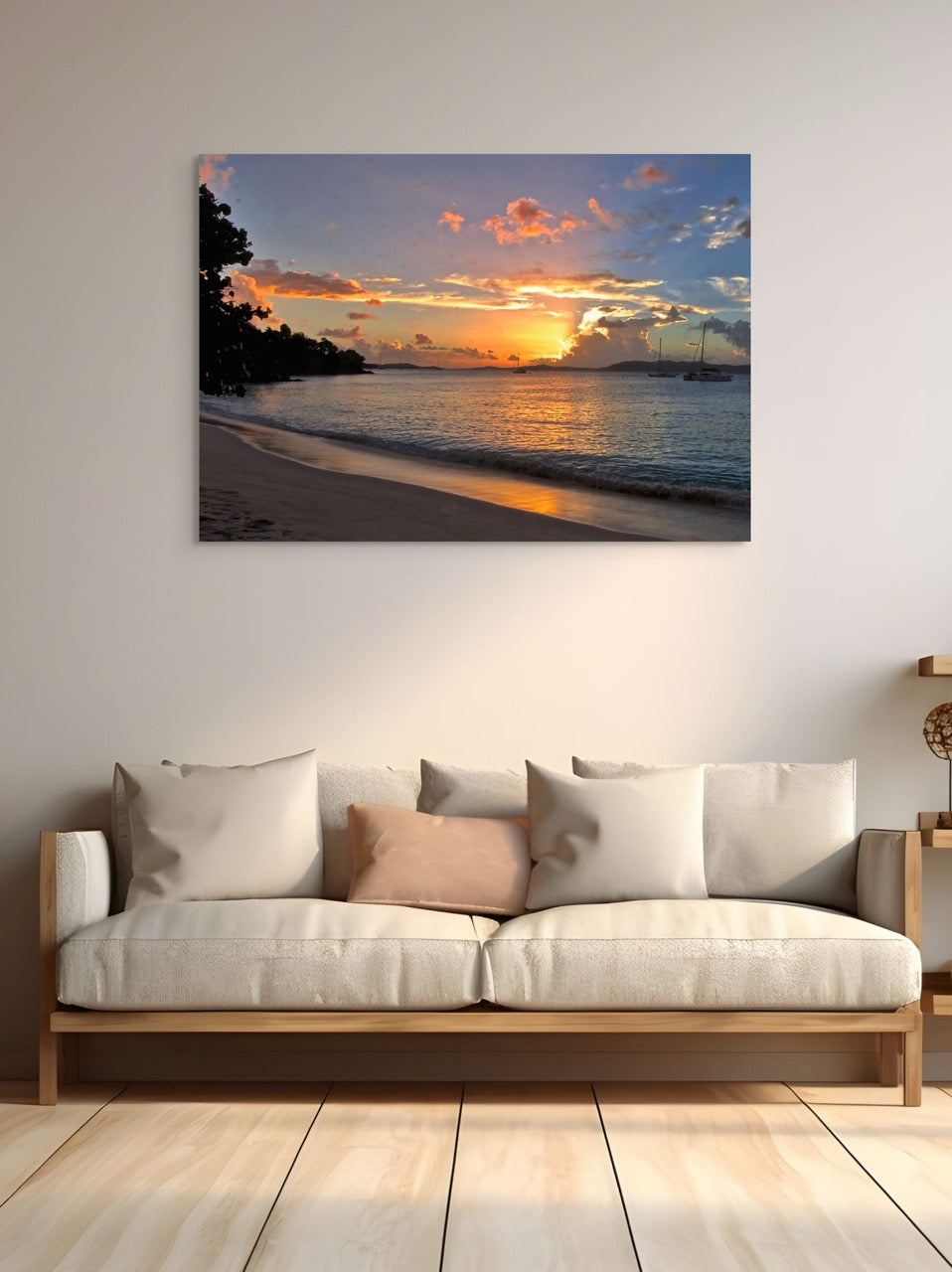 A tropical sunset canvas print  on a wall above a sofa with decorative pillows.