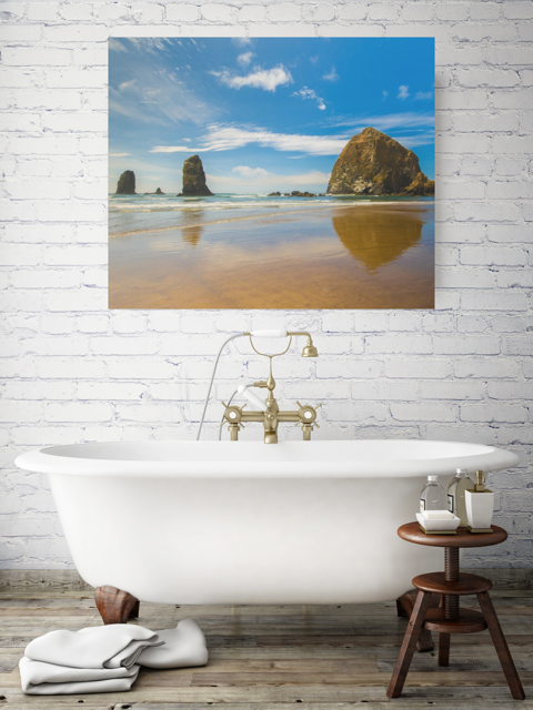 Bathroom with a freestanding bathtub and a large canvas print featuring a view of Haystack Rock and other rock off the coast of Cannon Beach, Oregon on the wall.