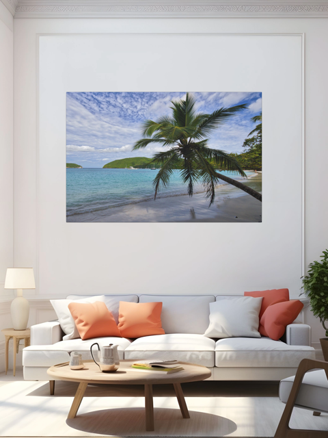 Living room with a white sofa, orange and white cushions, and a round wooden coffee table. A large canvas print of a tropical beach scene is on the wall.