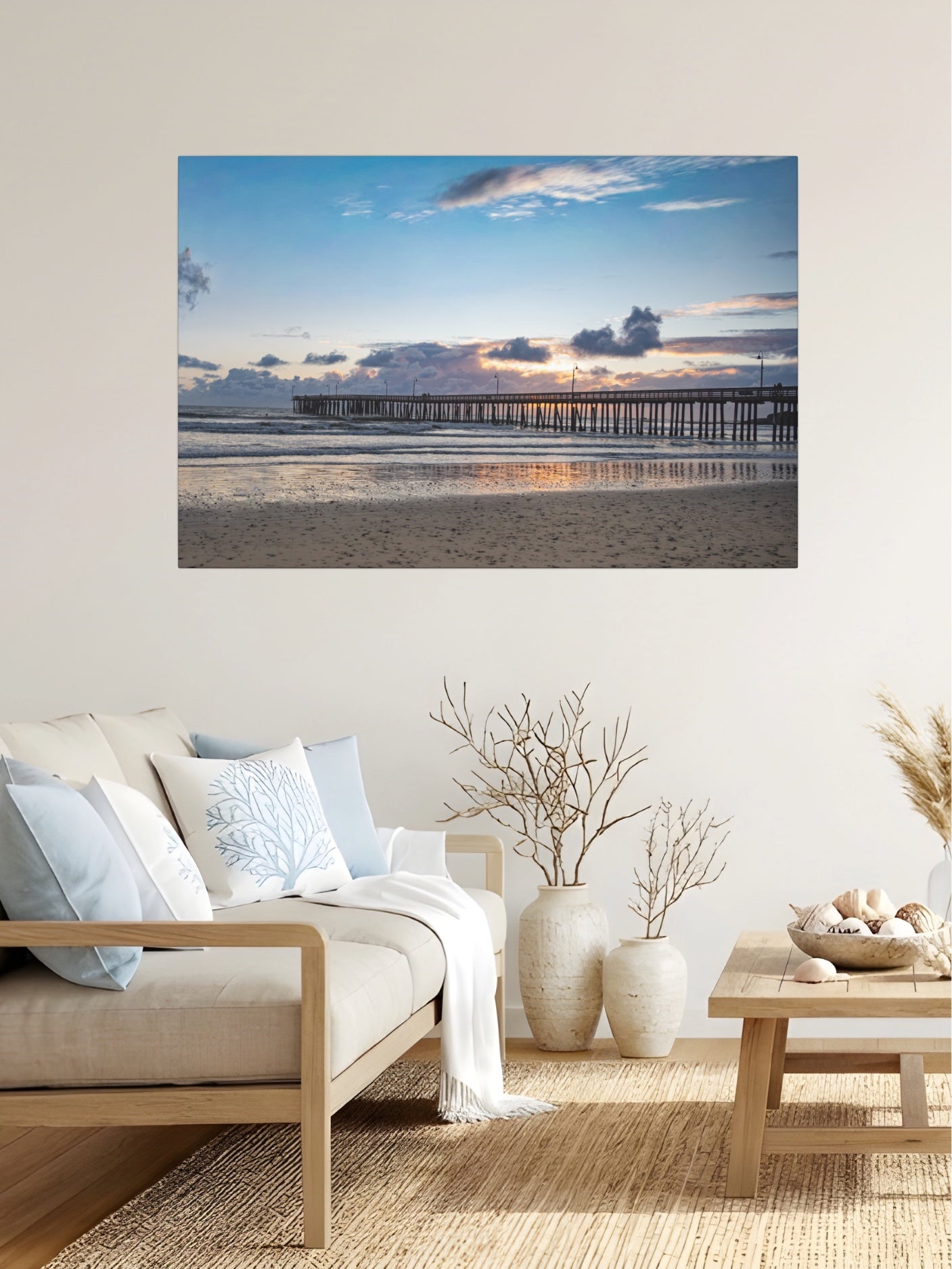 Cayucos Pier sunset canvas print on a wall above a sofa in a living room.