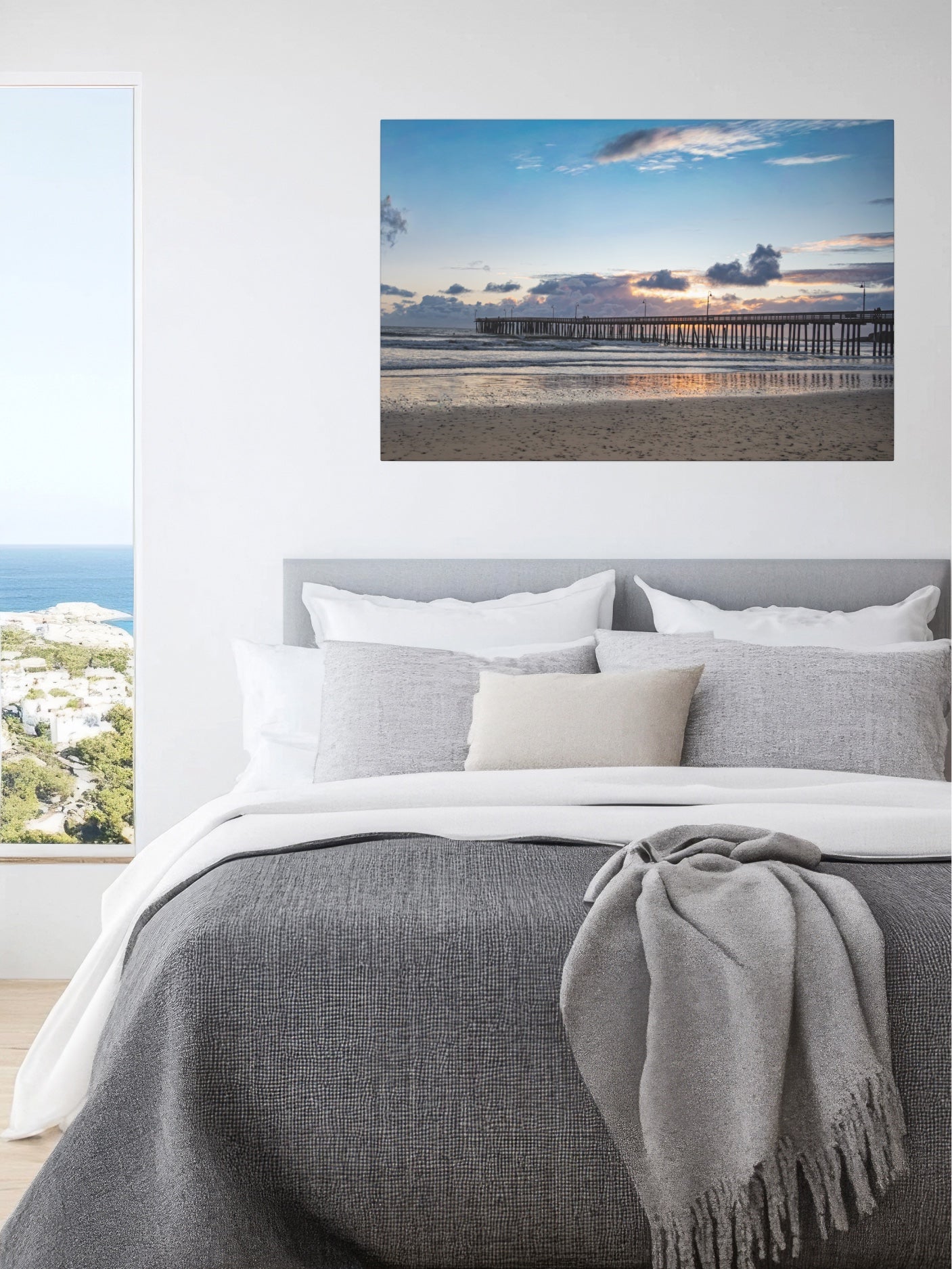 Bedroom with a Cayucos Pier sunset canvas print above the bed.