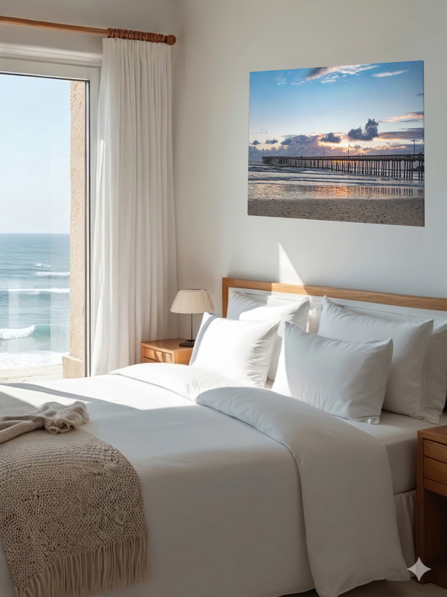 Bedroom with a large bed, ocean view, and a Cayucos Pier sunset canvas print on the wall.