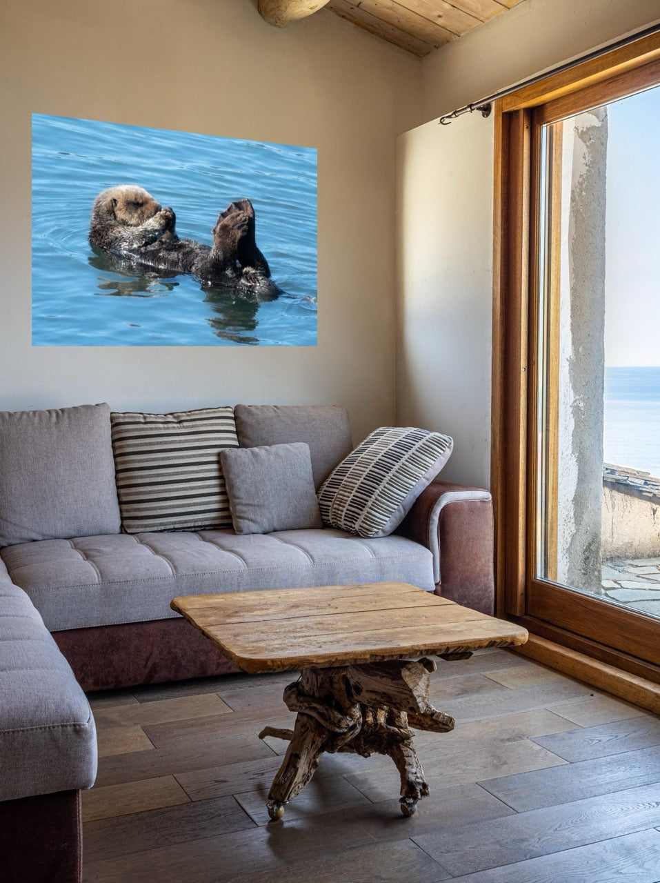 Living room with a sofa, coffee table, and wall art of a sea otter in water.