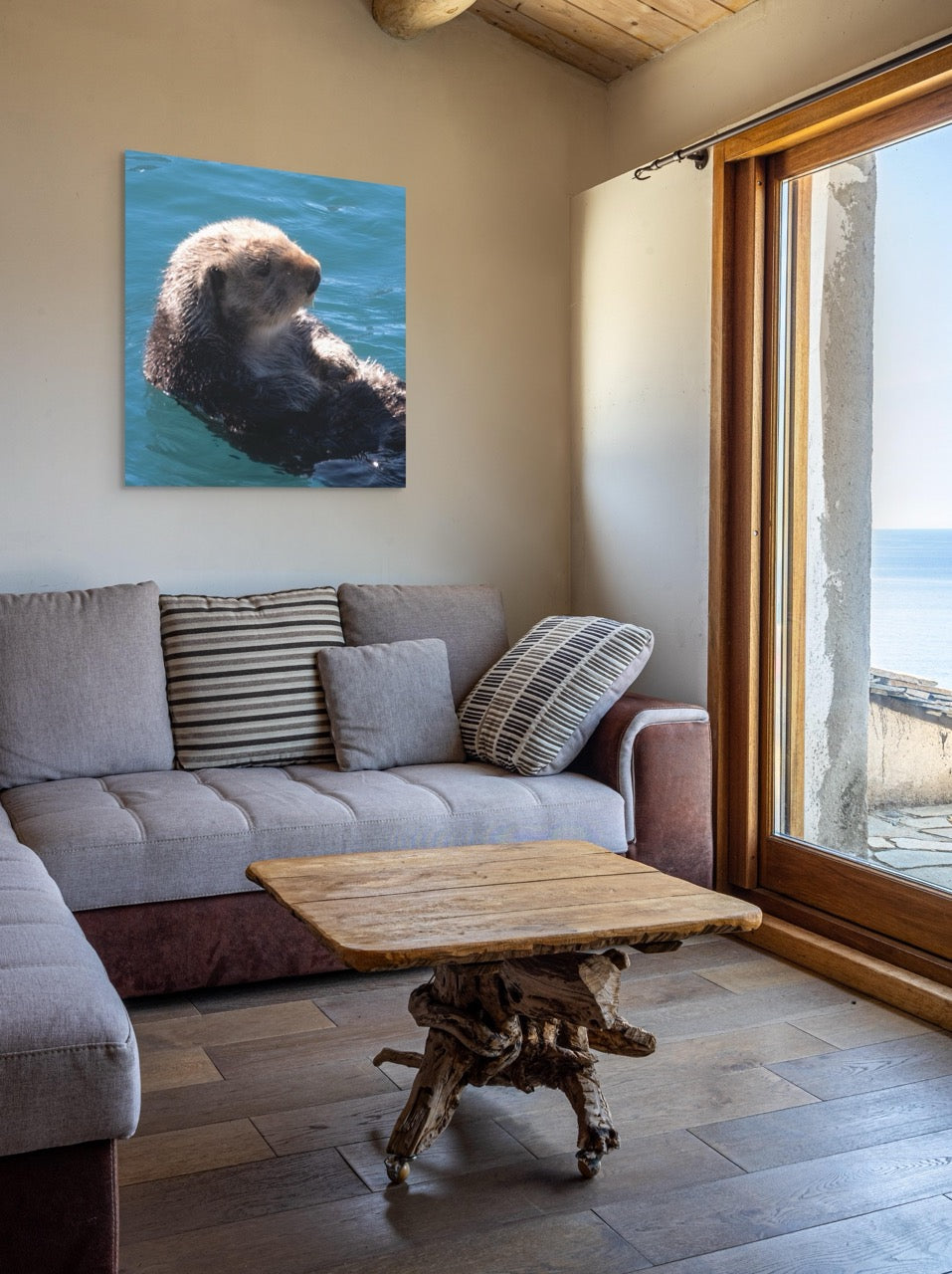 Living room with a gray sofa, wooden coffee table, and a canvas print of a sea otter on the wall.