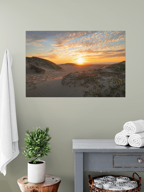 A canvas print of a beach dunes sunset over a grey side table.