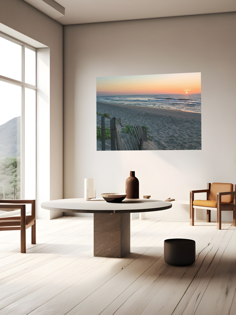 Modern living room with a canvas print of a coastal sunrise on a sandy beach with a weathered wooden fence on the wall