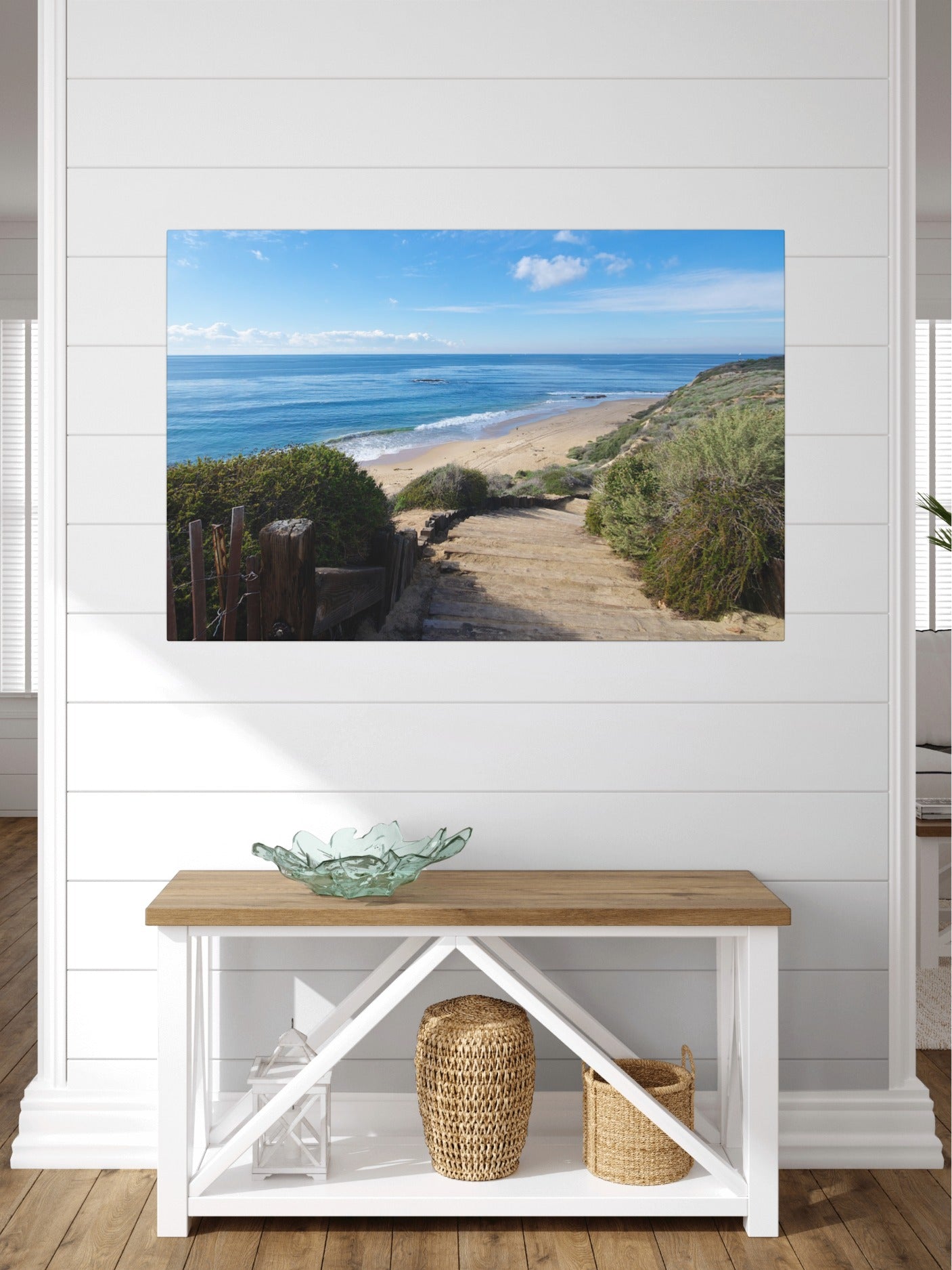 Canvas print of the wooden stairs leading to Crystal Cove State Beach in Orange County California on a wall above a wooden bench with decorative items.