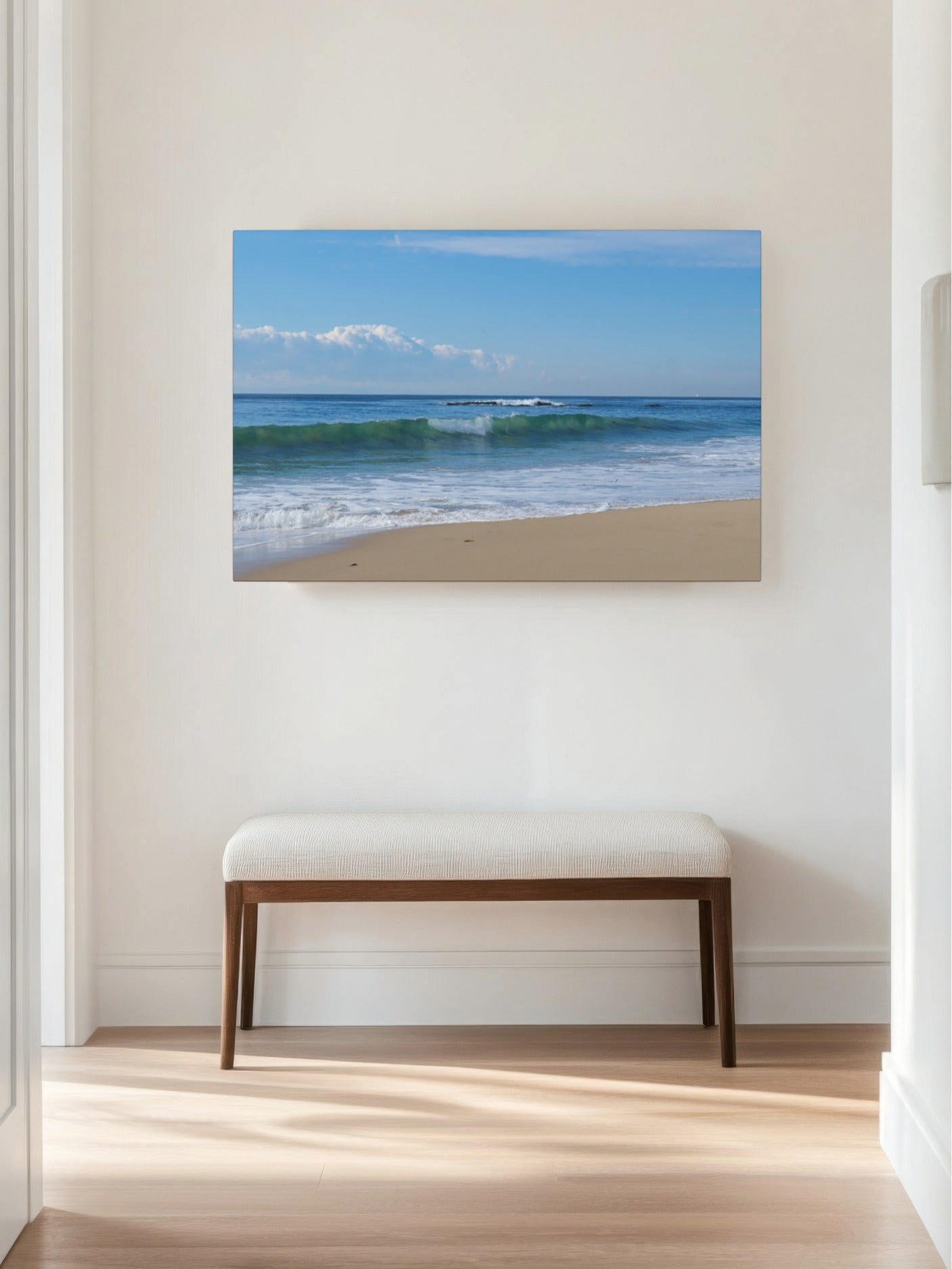 Crystal Cove State Beach breaking wave with translucent green water canvas print on a wall above a wooden bench in a room.