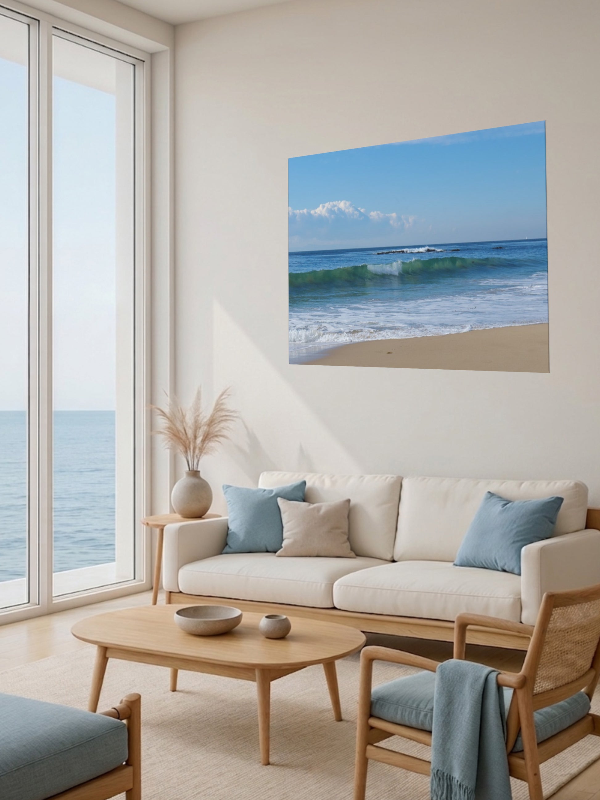 Living room with a large window view of the ocean, a beige sofa with blue cushions, and a Crystal Cove State Beach breaking wave with translucent green water canvas print.