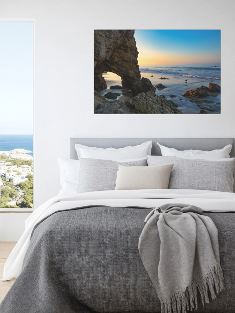 Bedroom with a canvas print of a sea cave at sunrise in Malibu.