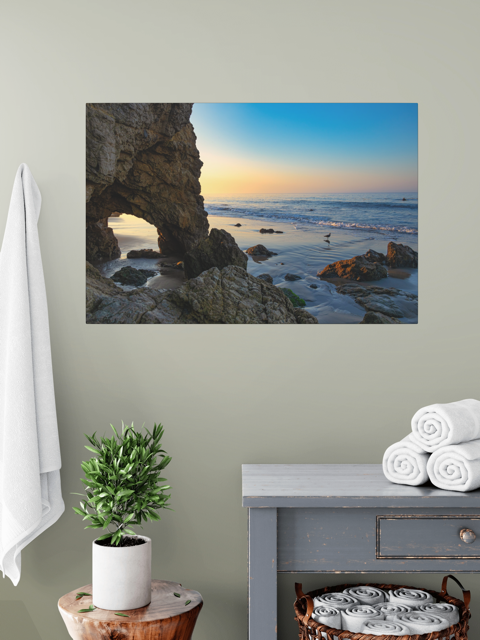 Canvas print of a sea cave at sunrise in Malibu in a room with a plant and towels.