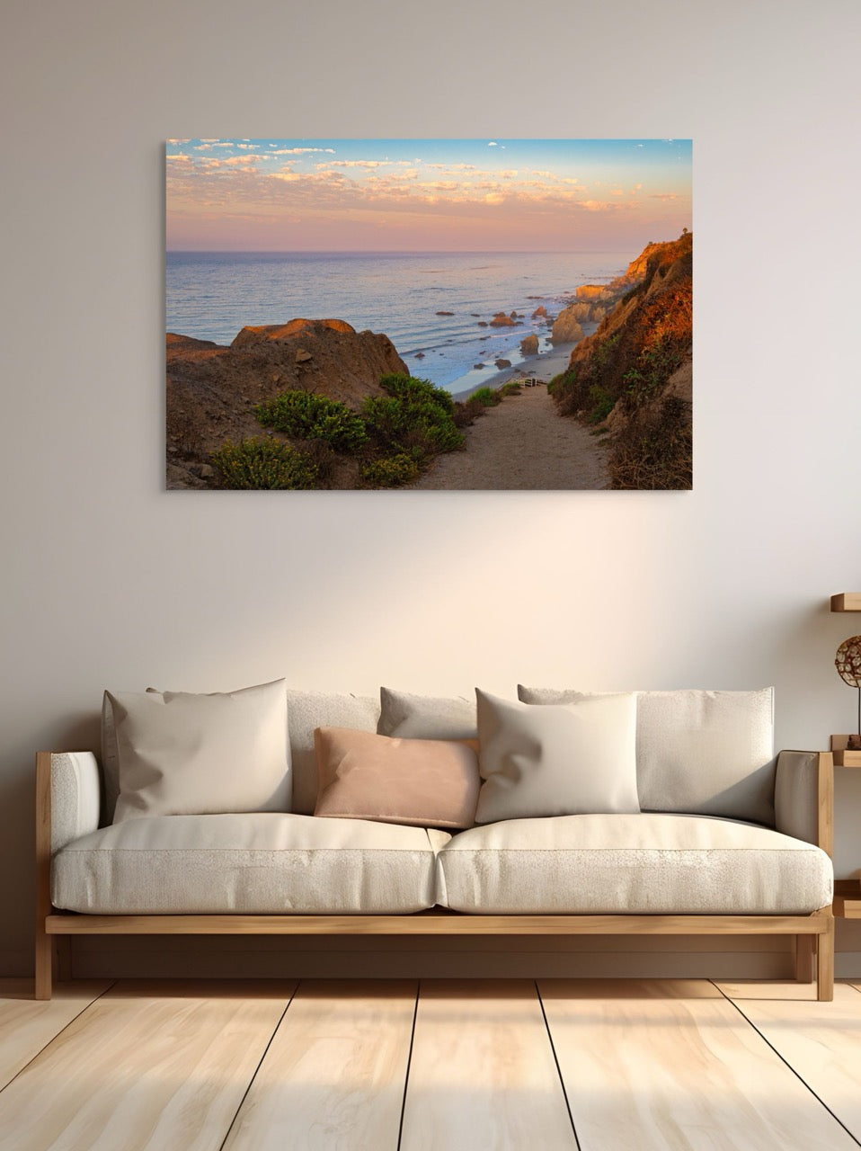 Sofa with decorative pillows in a room with a large wall art of a coastal landscape.