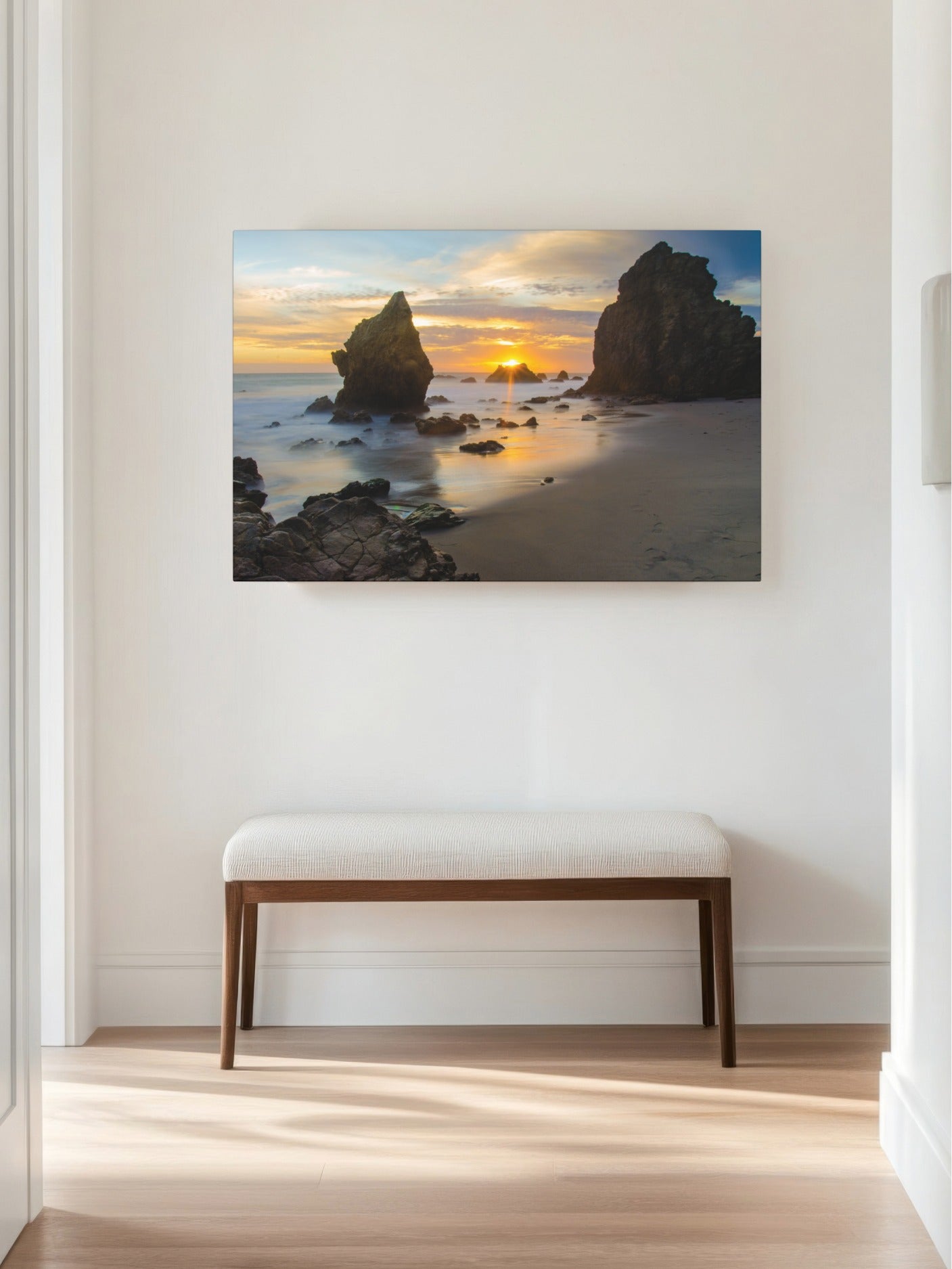 El Matador State Beach winter sunset with dramatic sea stacks and golden sunburst canvas print displayed on a wall above a bench.