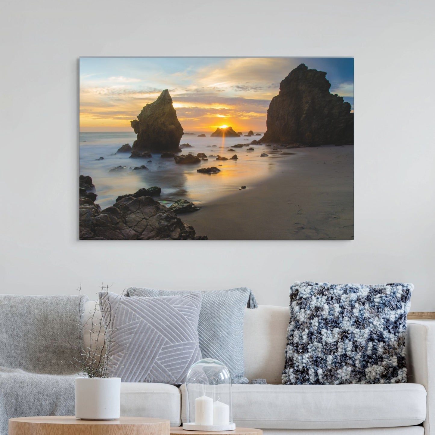 El Matador State Beach winter sunset with dramatic sea stacks and golden sunburst canvas print on a wall above a sofa with decorative pillows.