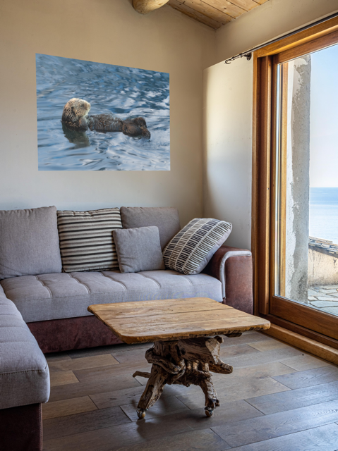 Living room with a gray sofa, wooden coffee table, and a floating sea otter canvas print.