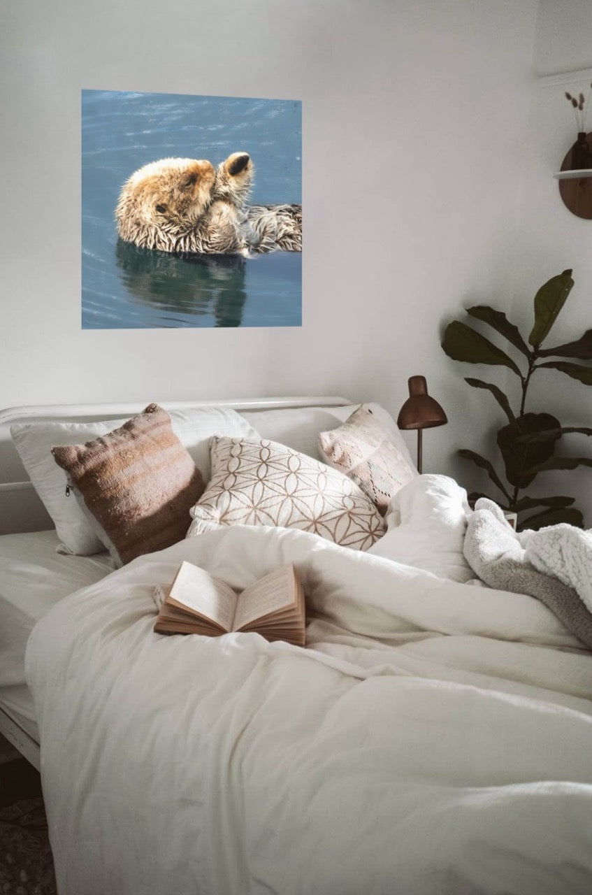 Bedroom with a wall art of a sea otter in water above the bed.
