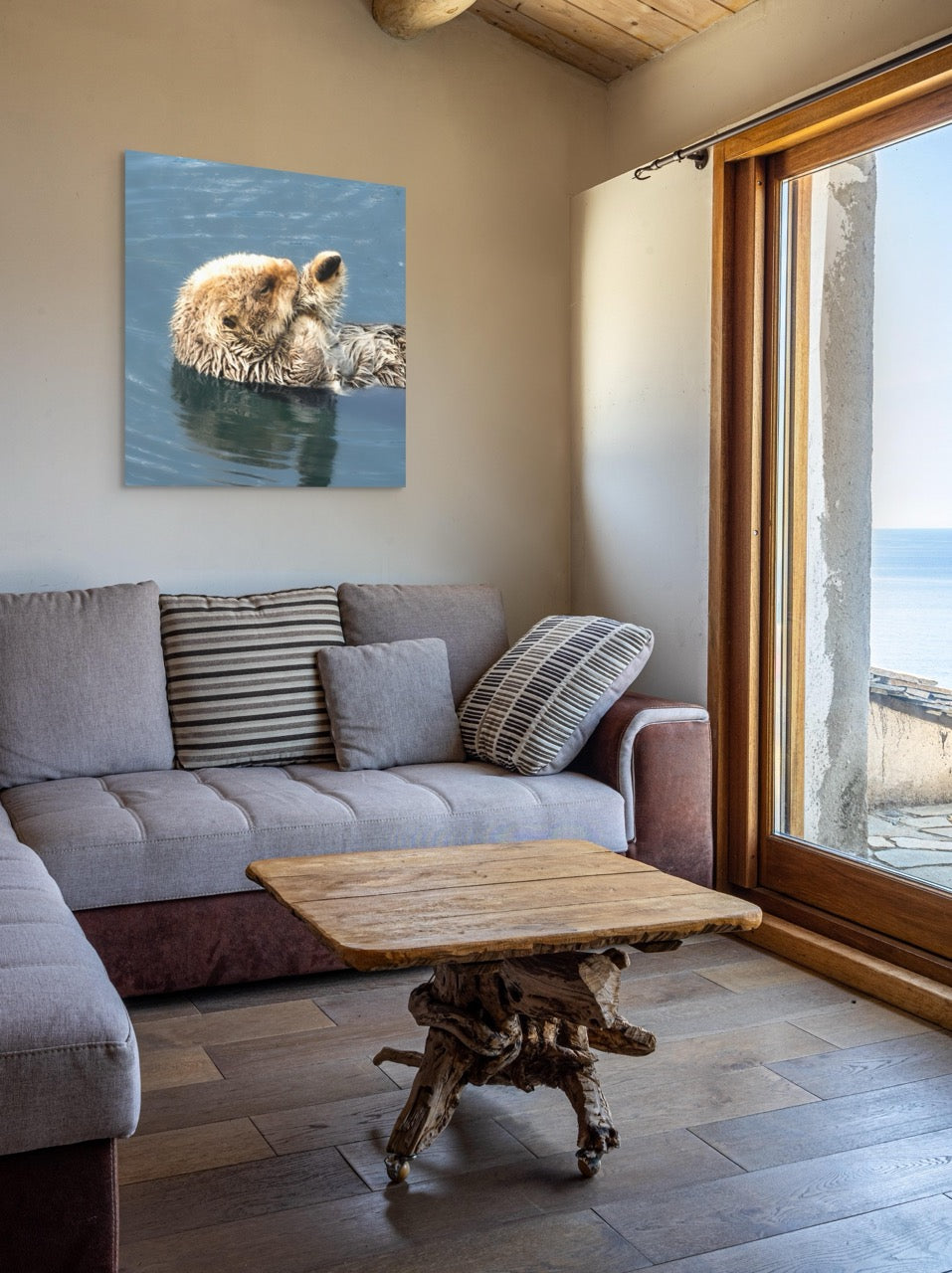 Living room with a gray sofa, wooden coffee table, and a canvas print of a sea otter on the wall.