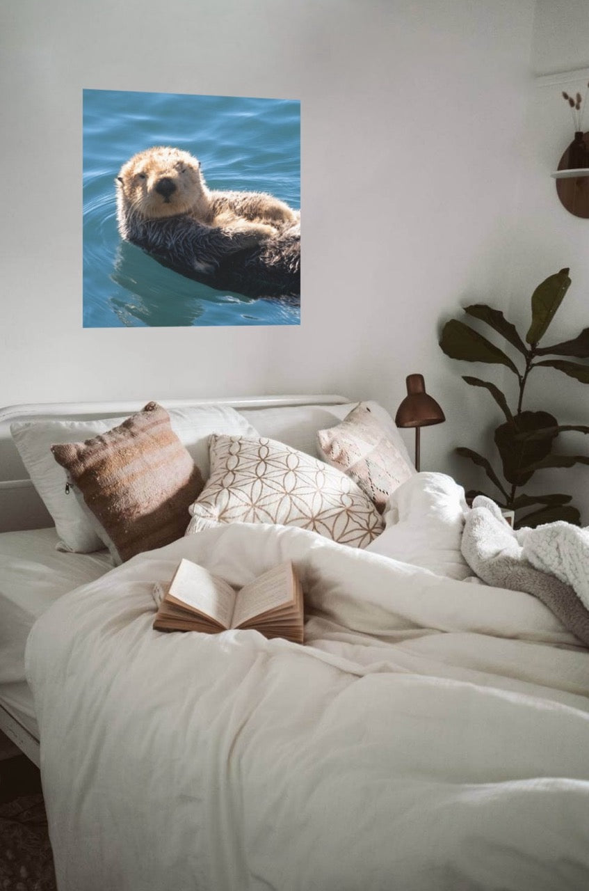 Room interior with a bed and wall art of a sea otter.