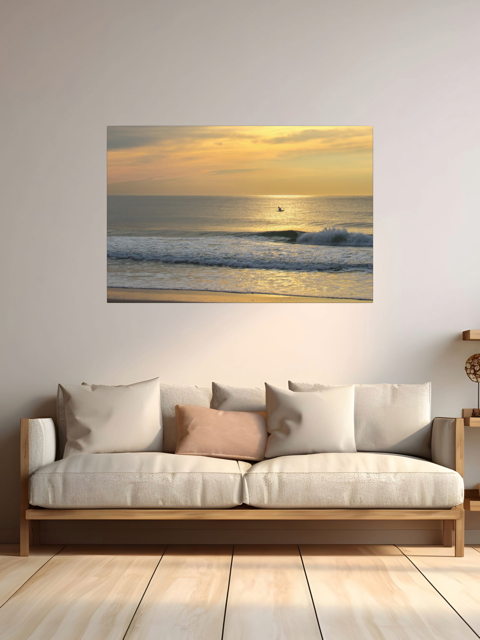 Sofa with decorative pillows in a room with a large canvas print of a bird in flight over the ocean at sunrise.