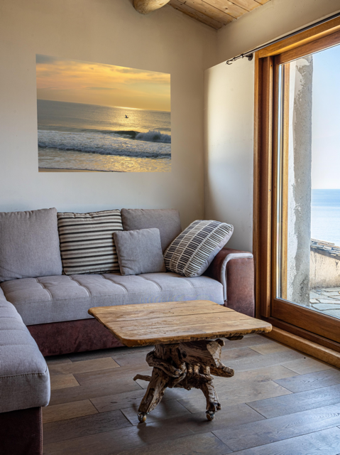 Living room with a gray sofa, wooden coffee table, and a large canvas print of a bird in flight over the ocean at sunrise.