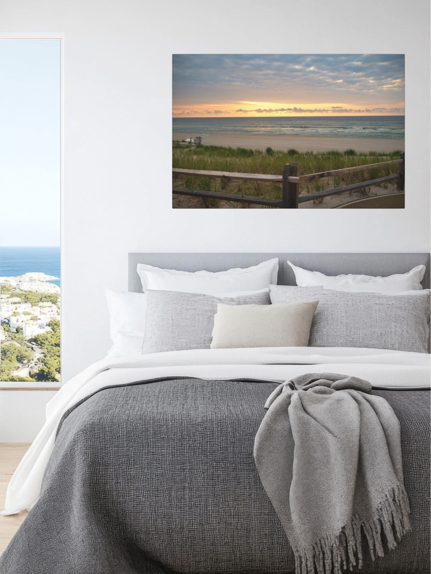 Bedroom with a lcanvas print of a Jersey Shore sunrise over the Atlantic Ocean with beach dunes and grass above the bed.