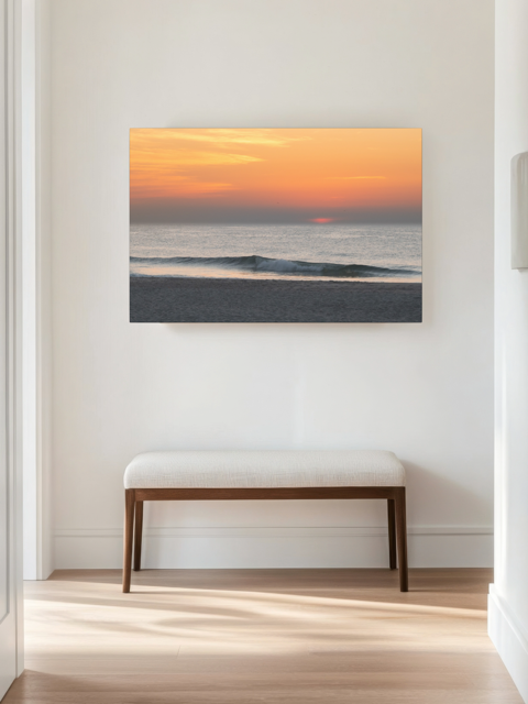 Canvas print of a hazy sunrise over the ocean down the Jersey Shore hanging on a wall above a wooden bench.