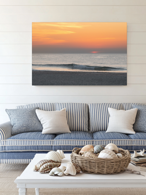 Living room with a couch, coffee table, and a canvas print of a hazy sunrise over the ocean down the Jersey Shore.