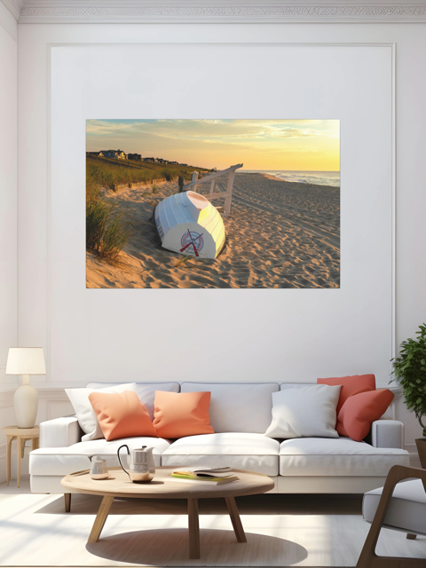 Living room with a canvas print of an overturned Jersey Shore Beach Patrol boat and lifeguard stand on the sand at sunrise with beach grass and rolling dunes on the wall above a sofa.