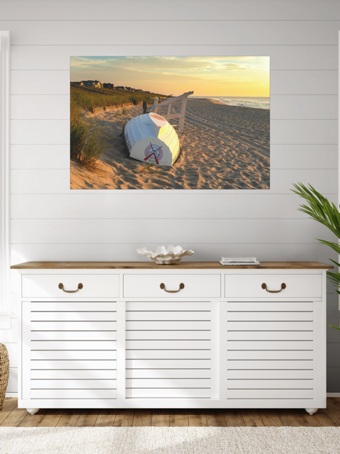 White cabinet with wooden top against a wall with a canvas print of an overturned Jersey Shore Beach Patrol boat and lifeguard stand on the sand at sunrise with beach grass and rolling dunes