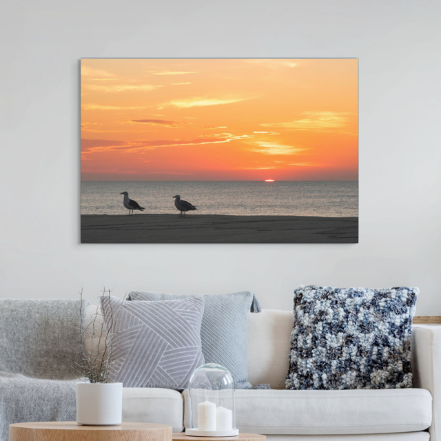 Living room with a large wall art of two seagulls standing on a sandy Jersey Shore beach during a vibrant orange sunrise over the Atlantic Ocean
