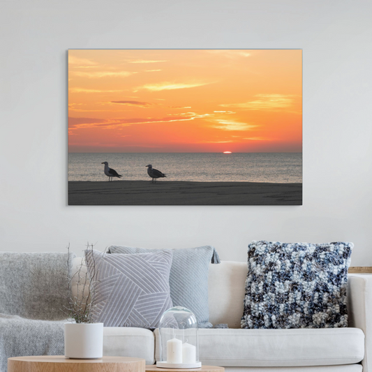 Living room with a large wall art of two seagulls standing on a sandy Jersey Shore beach during a vibrant orange sunrise over the Atlantic Ocean